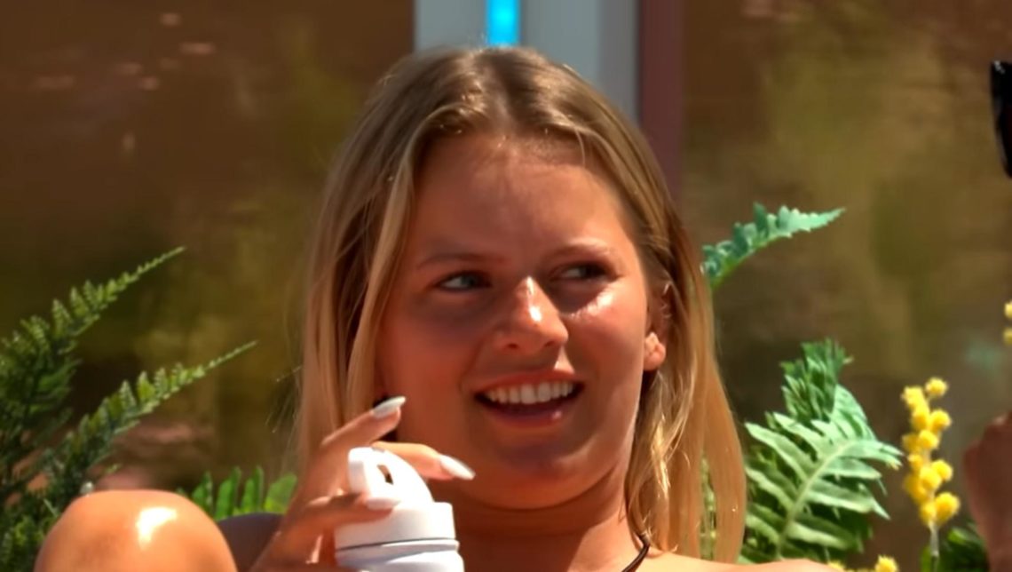 Tasha Ghouri holds Love Island bottle and looks eyes to right.