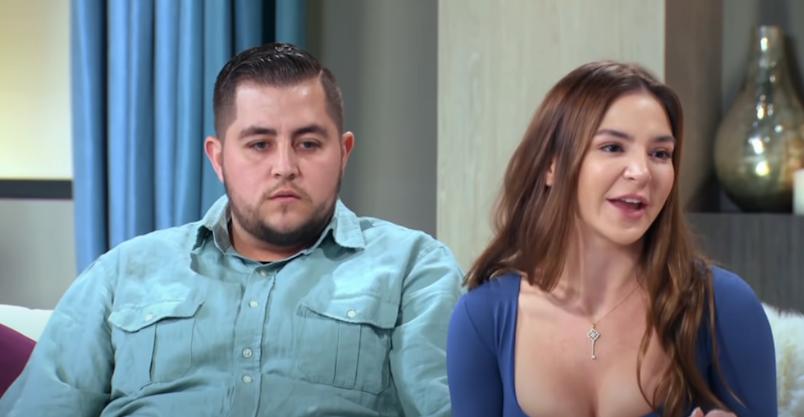Jorge Nava and Anfisa Arkhipchenko sat on a sofa during the 90 Day Fiancé: Happily Ever After? reunion