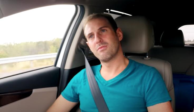 Todd Beasley sat in a car with his head tilted to the right, wearing a turquoise t shirt and a grey seatbelt across his body