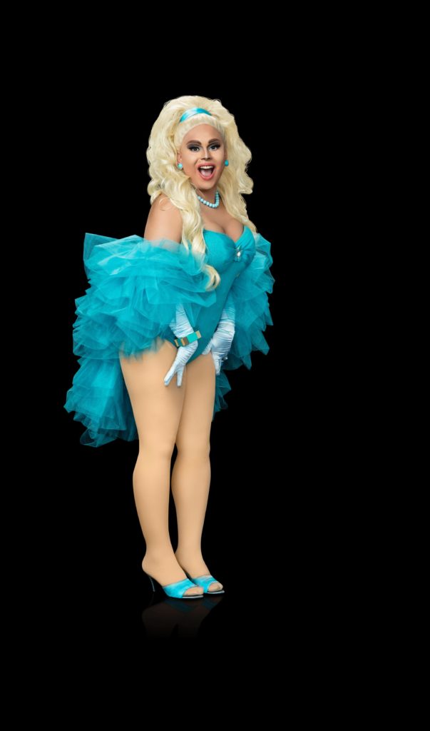 Drag Queen Jaymes Mansfield playfully pushes out his bottom in a blue leotard and fluffy scarf for a Promo for RuPaul Drag Race Season 9