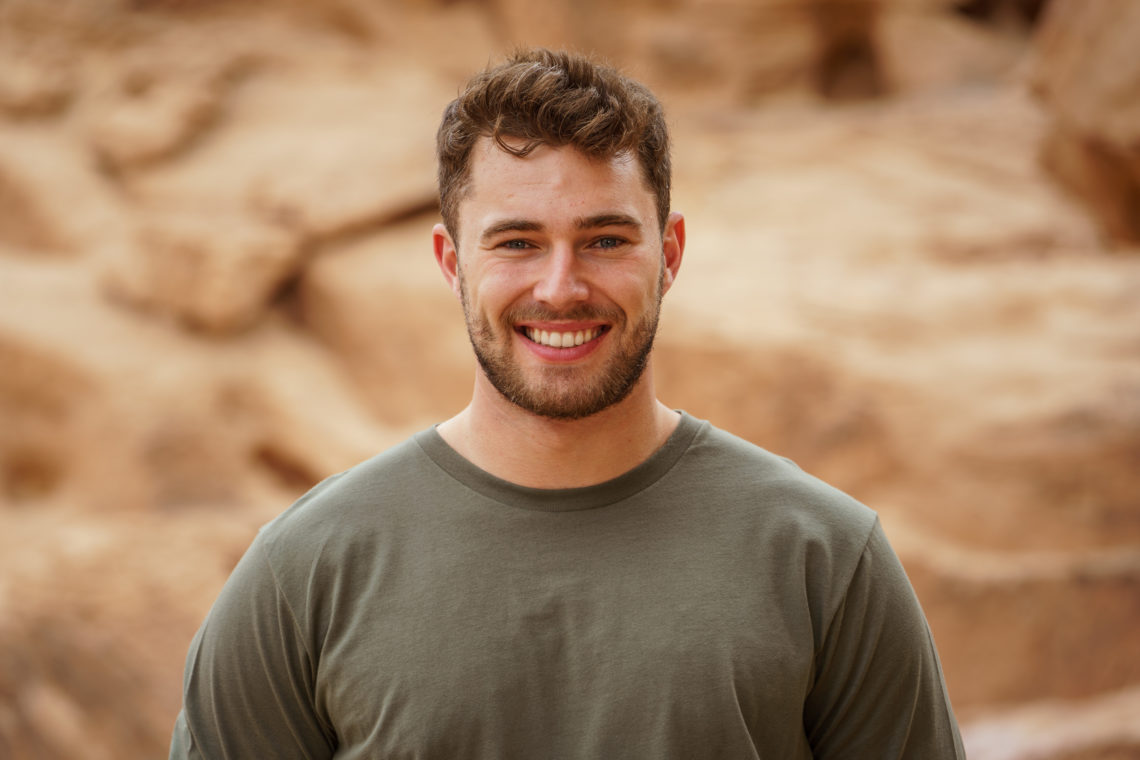 Curtis Pritchard wears green shirt smiling in front of rocks.