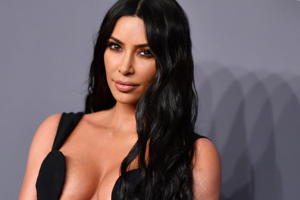 Kim Kardashian poses facing the camera wearing a black strappy dressUS-FASHION-ENTERTAINMENT-AMFAR