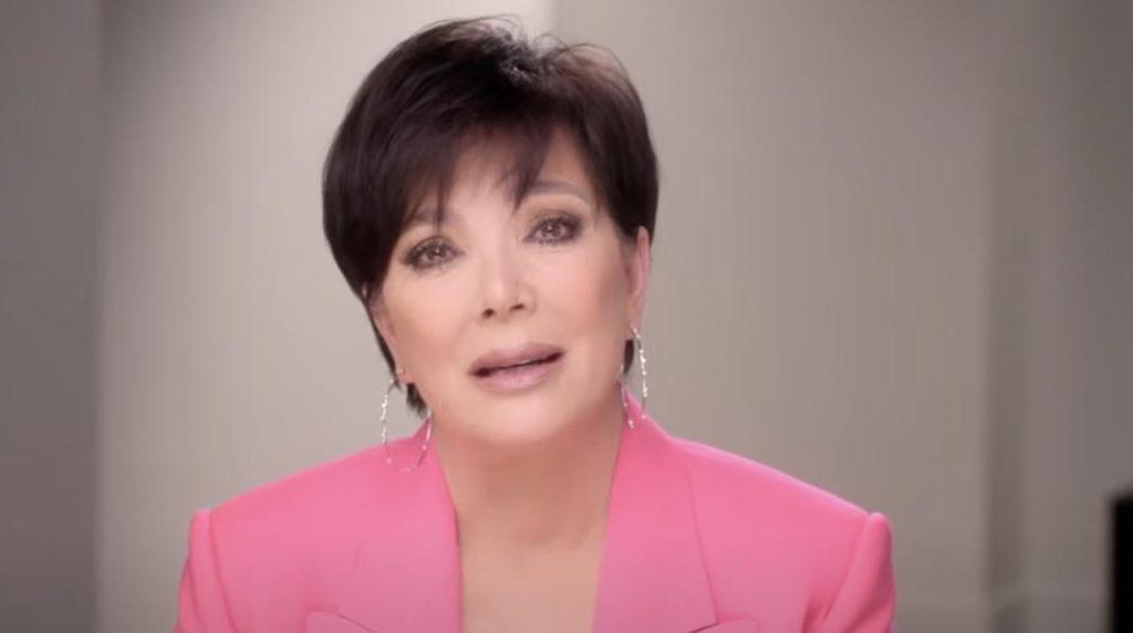 Kris Jenner seats in the confessionary teary-eyed wearing a pink blazer and hoop earrings