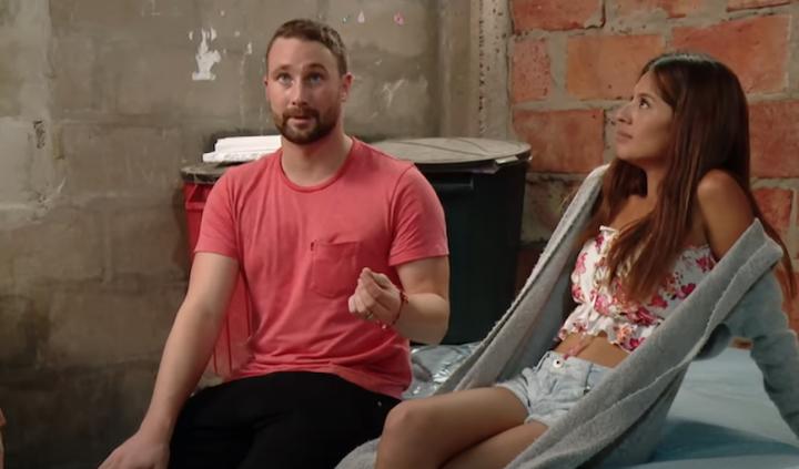 Corey and Evelin sit on a bed on 90 Day Fiancé