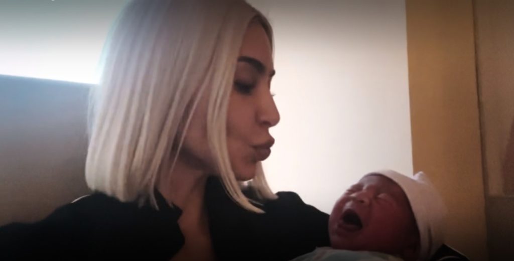 Kim Kardashian holds her nephew and kisses him on the head