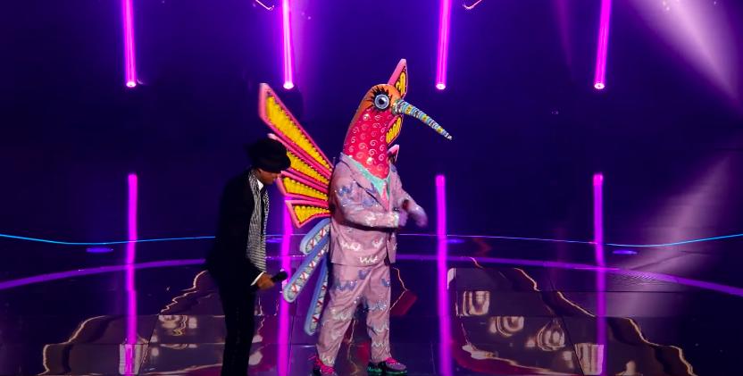 Nick Cannon and Humminbird stand on The Masked Singer stage