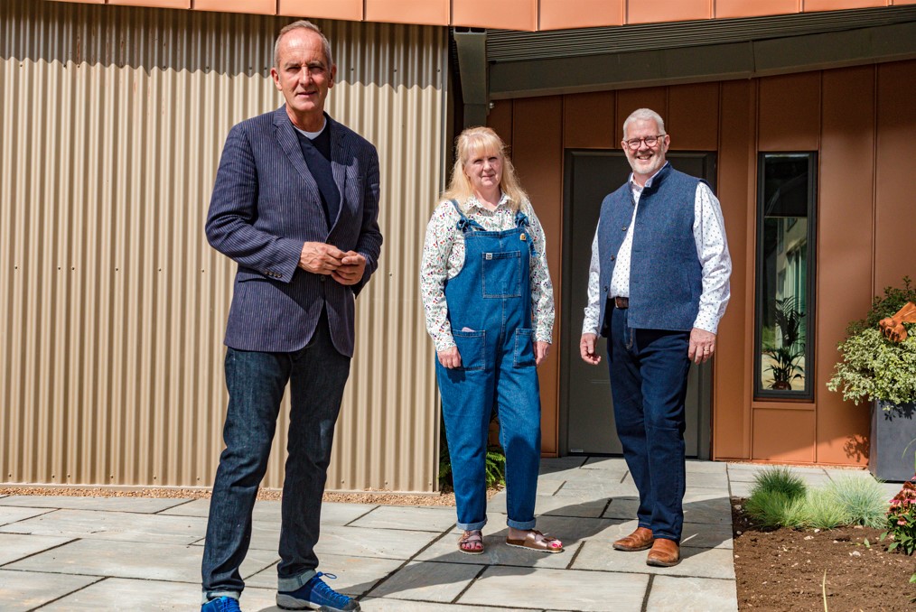 Mike and Sarah pose outside their home with Grand Designs' Kevin McCloud