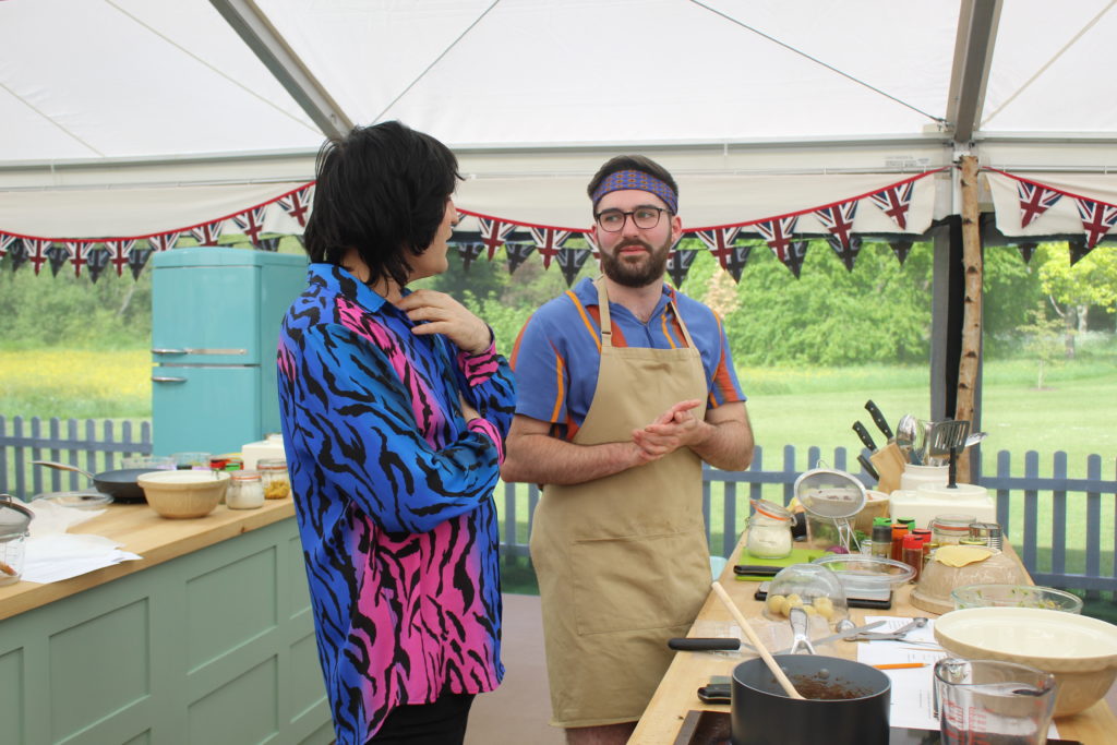 Noel Fielding (left) speaks to James in Great British Bake Off tent. 