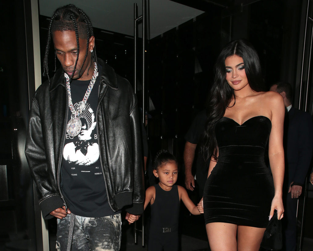 Travis Scott, Stormi Webster and Kylie Jenner are seen walking together holding hands wearing black near Nobu Portman Square on August 04, 2022 in London, England