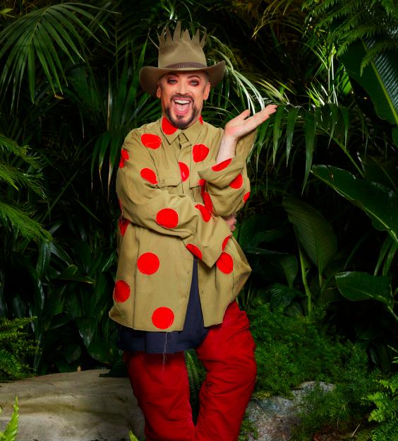 Pop icon Boy George in a beige and red polka dot shirt with red trousers and an explorer hat, against the backdrop of a jungle for I’m A Celebrity…Get Me Out Of Here! 2022.
