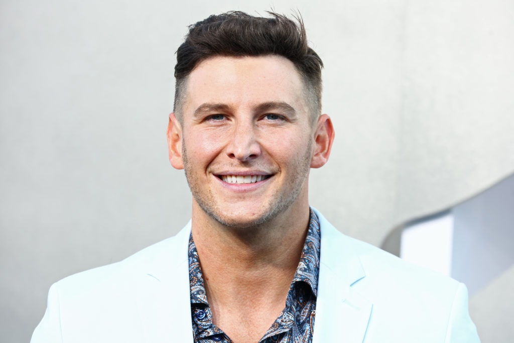 Blake Horstmann portrait photo, he smiles for the camera wearing a light blue suit and blue patterened shirt at the 2022 MTV Video Music Awards