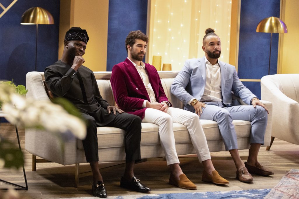 SK Alagbada, Cole Barnett and Bartise Bowden wear suits while sitting on cream sofa.