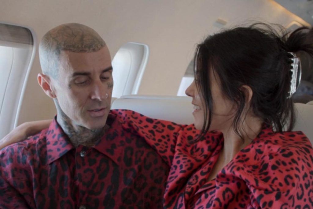 Travis Barker holds wife Kourtney Kardashian's hand as they say a prayer before a plane takes off