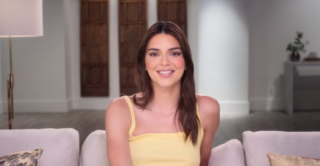 Kendall Jenner wears a yellow top as she smiles at the camera on The Kardashians