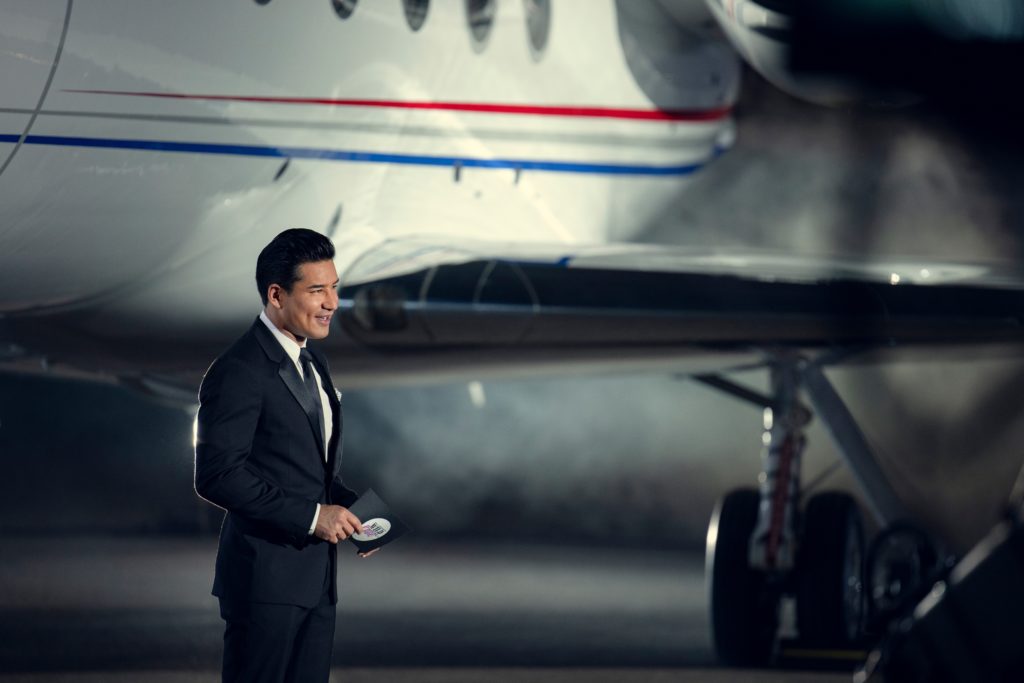 Mario Lopez standing next to airplane