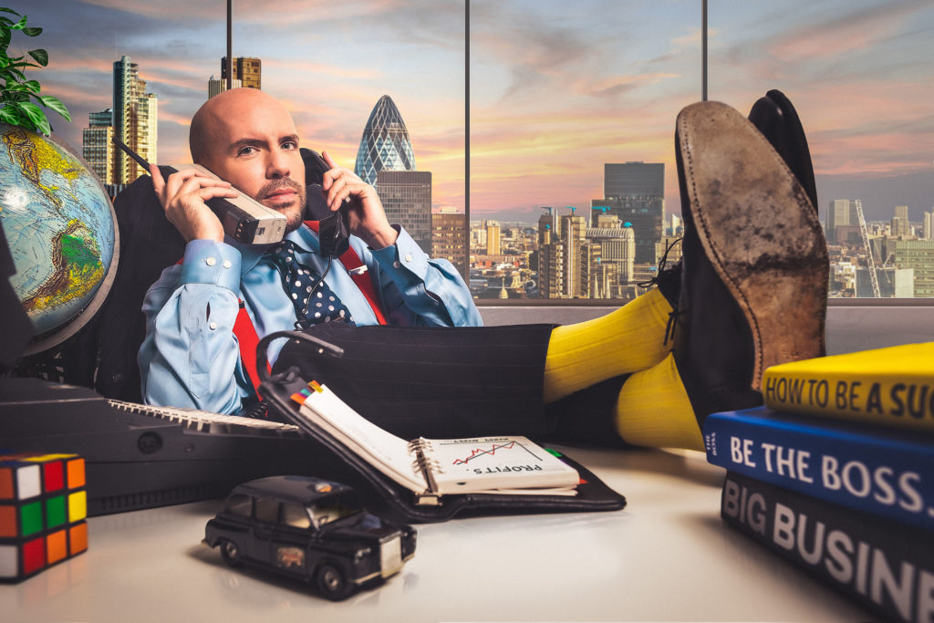 Tom Allen The Apprentice You're Fired with feet up on the table on the phone