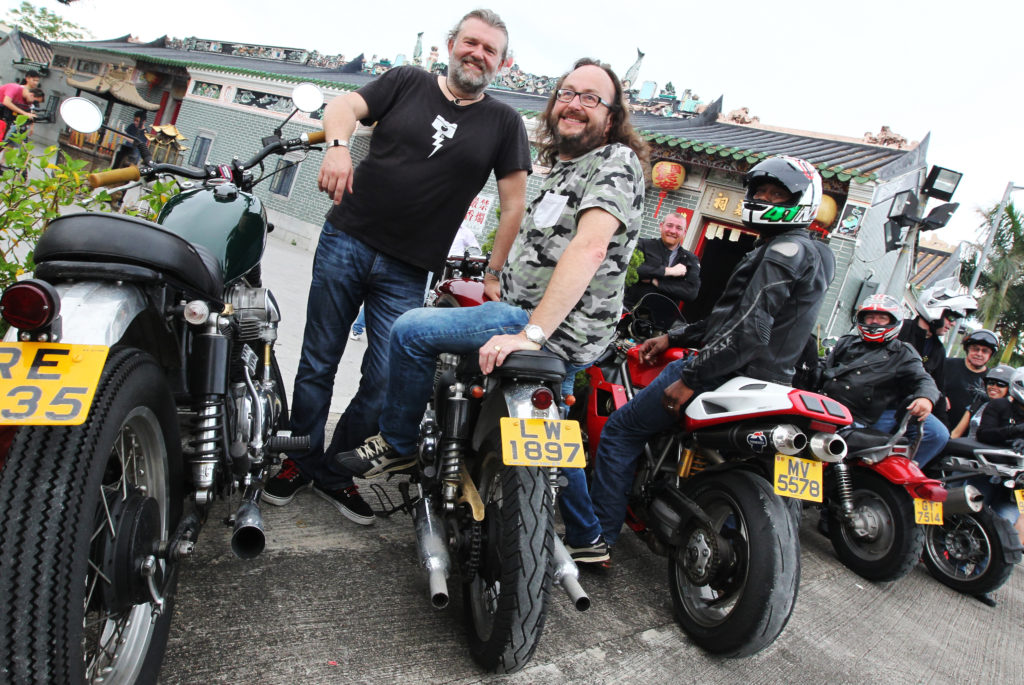 British celebrity TV chefs Simon King (L1 in black top) and David Myers (L2 in camouflage top), collectively known as "The Hairy Bikers", arrive at a Tin Hau Temple in Yuen Long as they film their new culinary series with local bike enthusiasts for BBC. 2