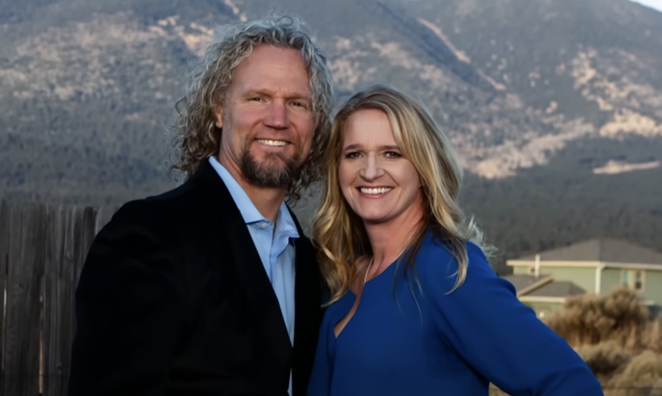 Picture of Kody in a suit with a blue shirt and Robyn Brown in a blue long sleeve top both smiling at the camera