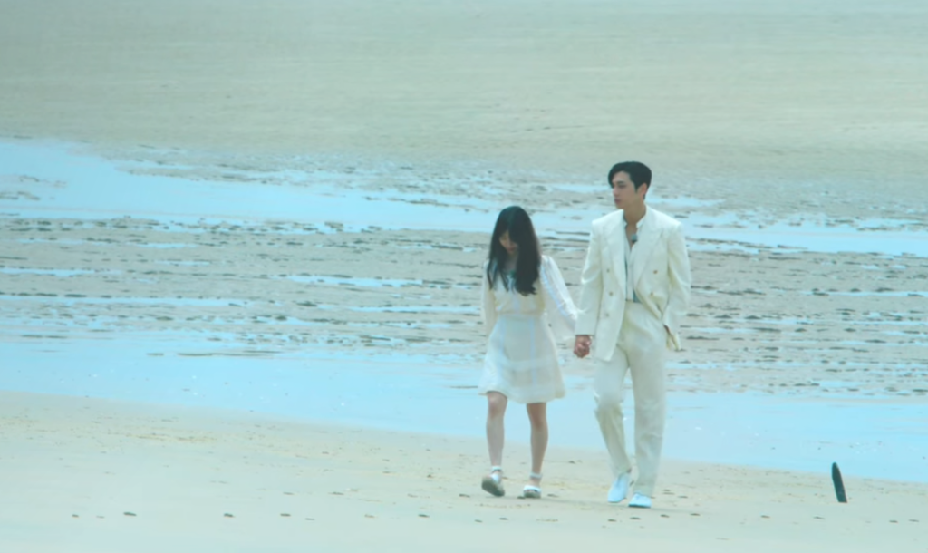lee so e and kim se jun stand together on the beach