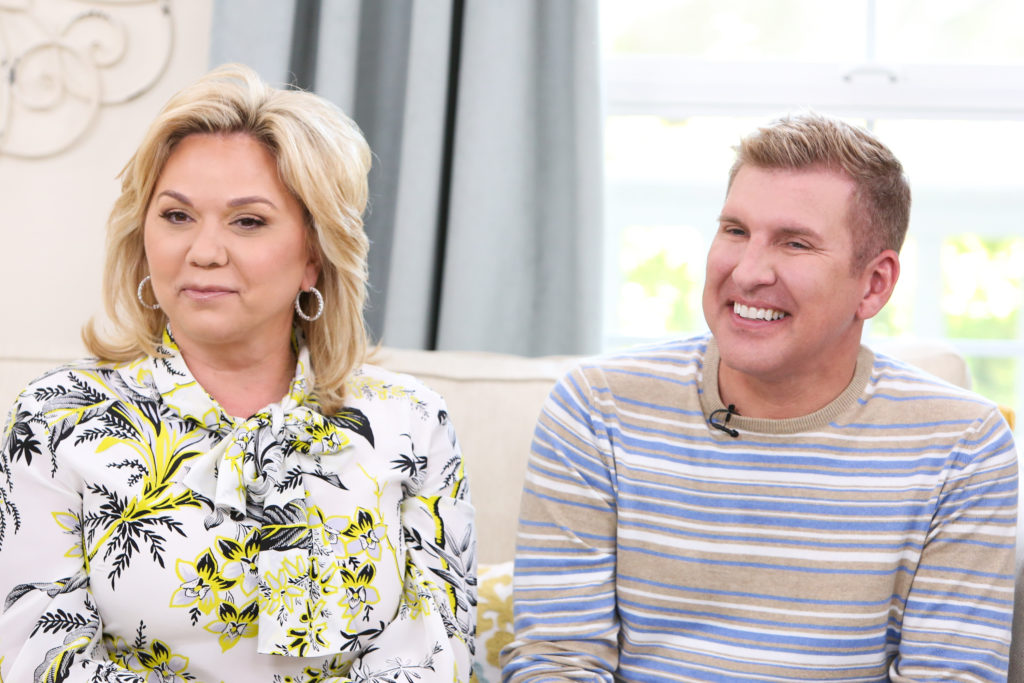 Todd and Julie Chrisley look across camera wearing neutral toned clothing