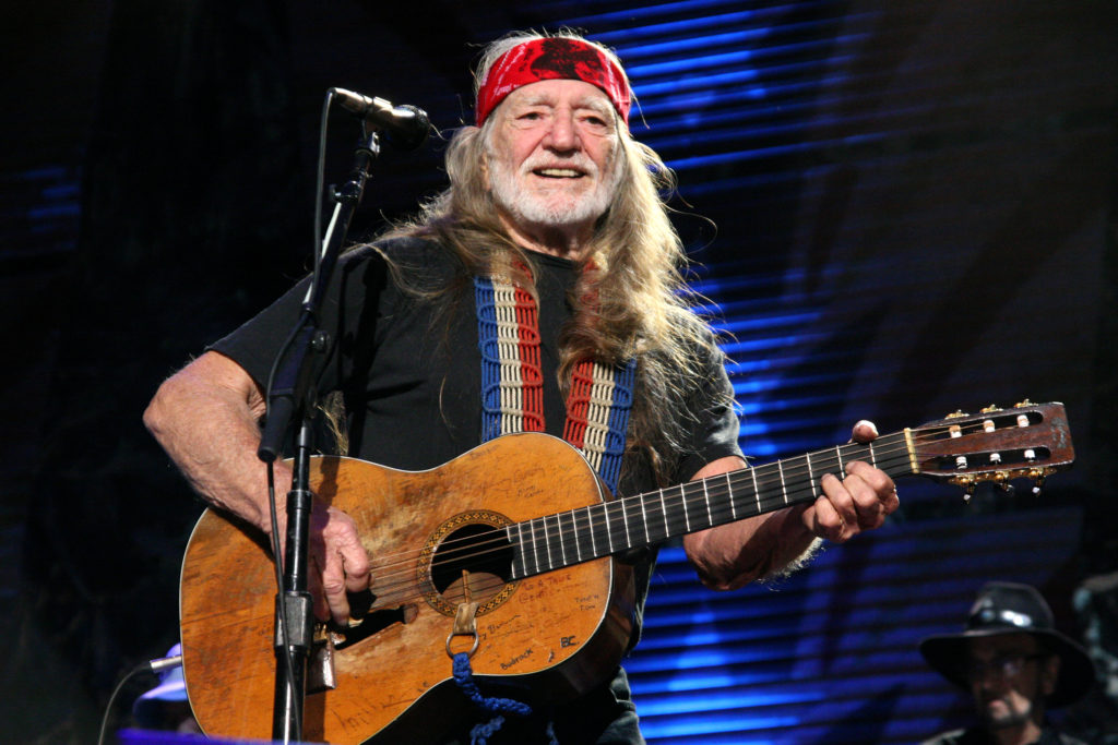 Willie Nelson performs with guitar on stage at Farm Aid 2009
