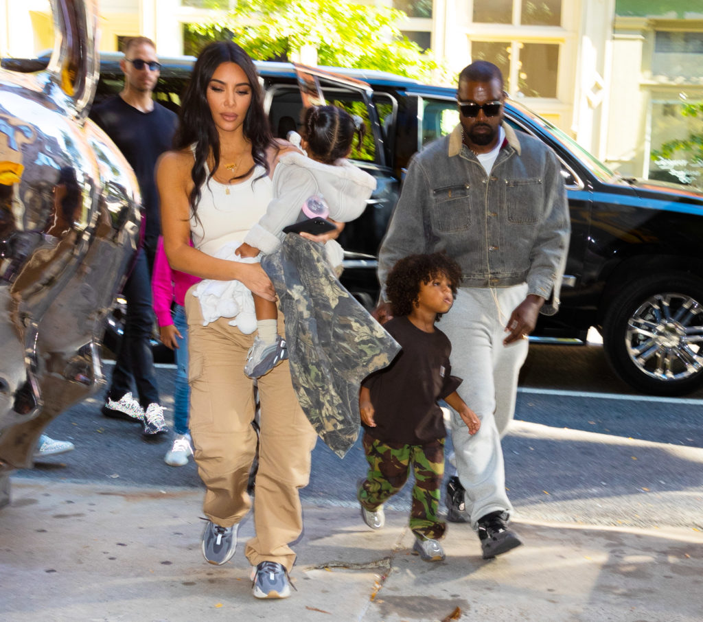 Kim Kardashian, Kanye West, Chicago West, Psalm West walk on sidewalk together