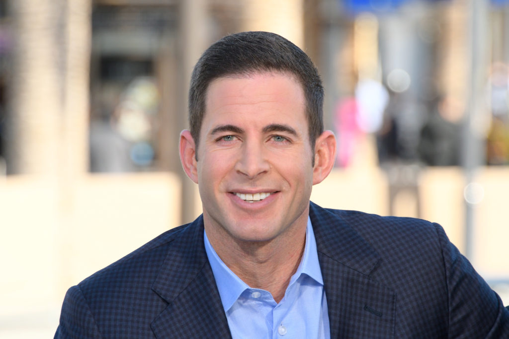 Tarek El Moussa looks into camera wearing blue shirt and navy suit jacket smiling