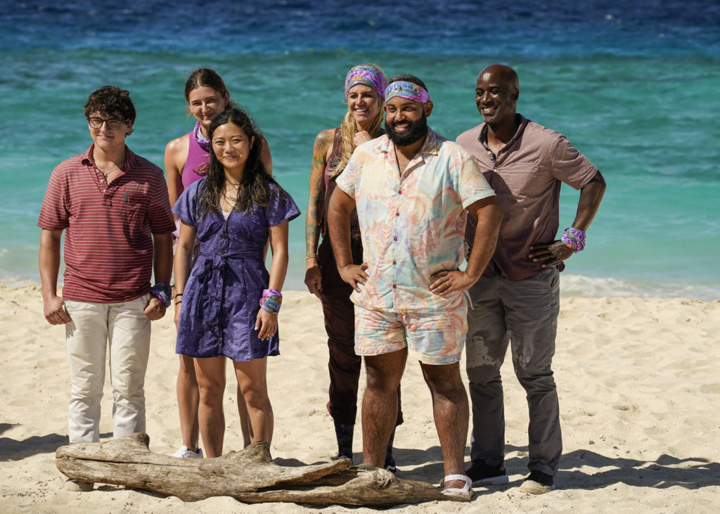 Survivor 44 contestants Carson Garrett, Sarah Wade, Helen Li, Yamil "Yam Yam" Arocho, and Bruce Perreault. stand together on beach