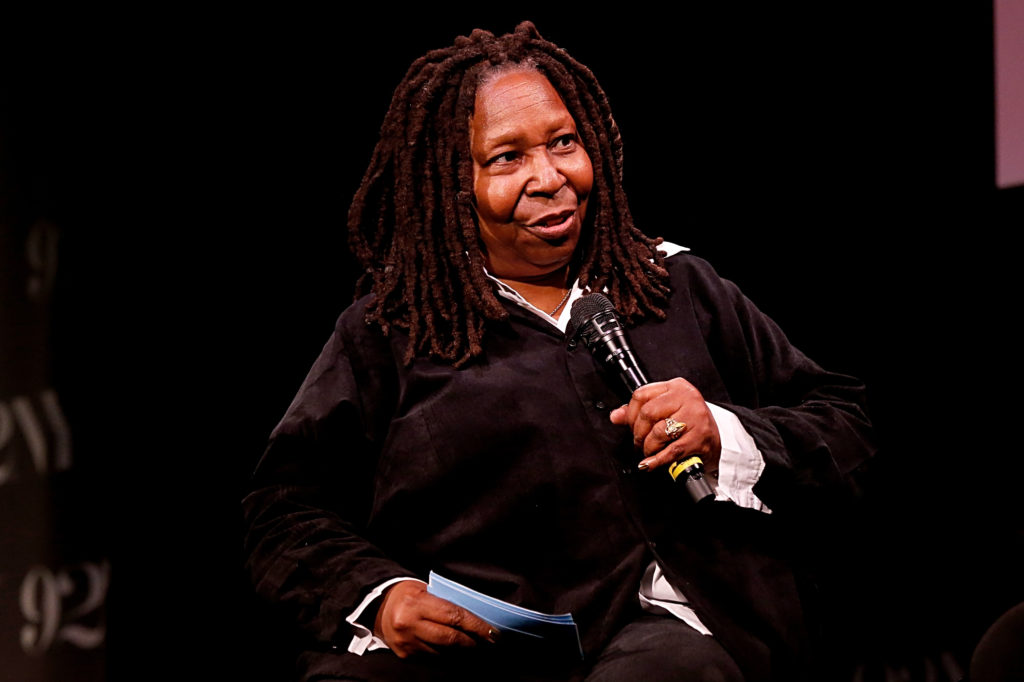 Whoopi Goldberg holds microphone to mouth wearing black sweater and white shirt at MGM+'s "Godfather Of Harlem" Special Screening And Conversation