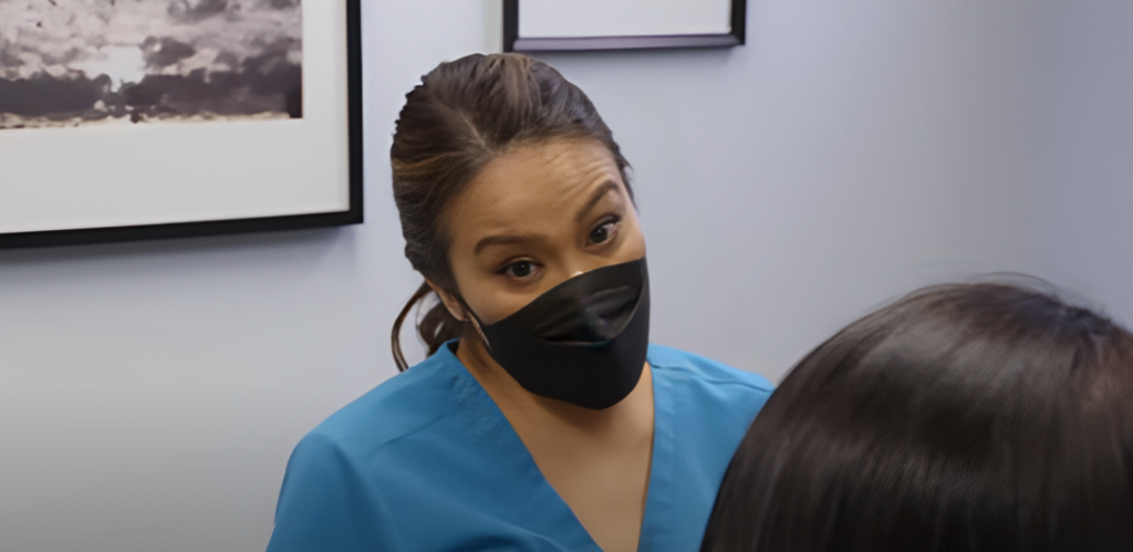 Dr Pimple Popper raises eyebrows at patient who is out of shot wearing black mask and SLMD blue top
