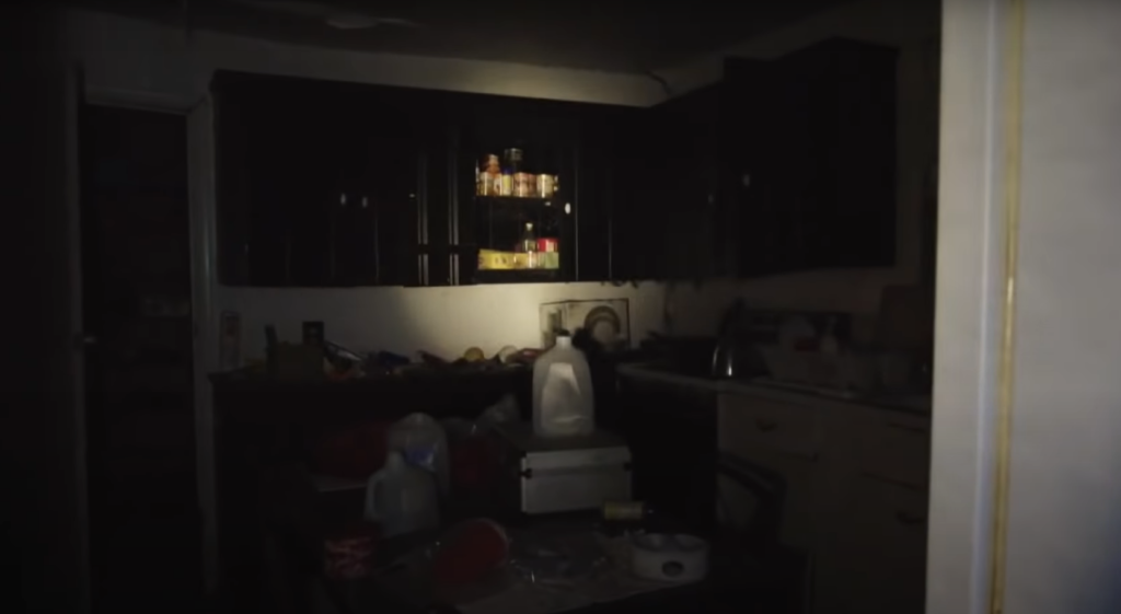Old abandoned kitchen in dark with single spotlight shining on cupboards