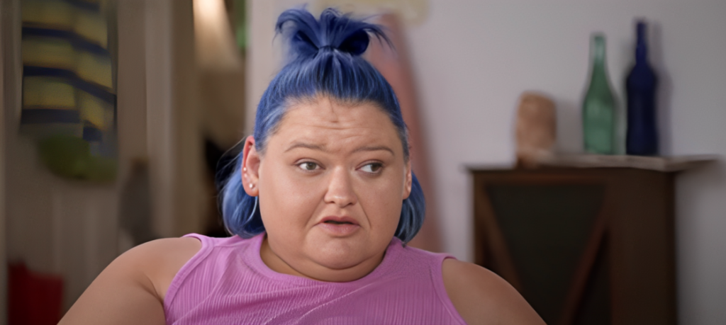 Amy Slaton looks shocked speaking to camera on 1000-lb Sisters wearing pink top and blue hair