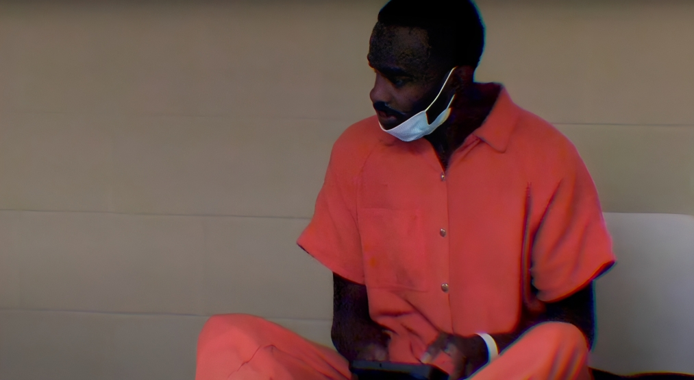 60 Days In season 8 cast member sitting in an orange jumpsuit with mask