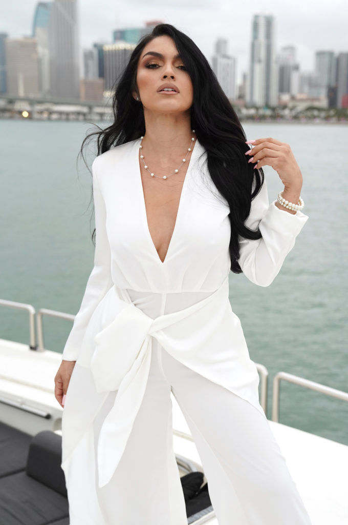 Kaile poses wearing white jumpsuit