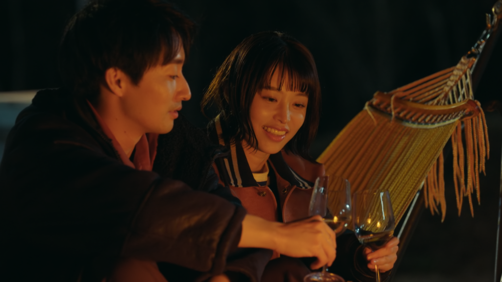 Robin Furuya and Julie clink wine glasses while smiling.