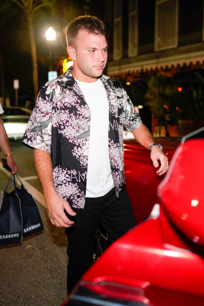 Chase Chrisley wears floral shirt getting into red car in Miami
