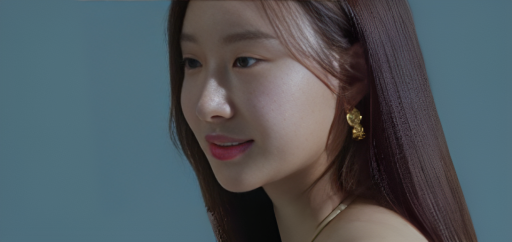 An Min-Young smiles looking to left of camera, wearing gold ring on right earlobe.